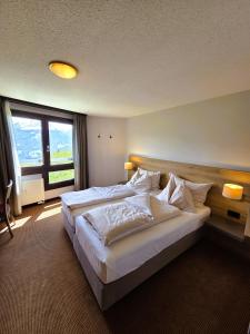 a bedroom with a large bed with a large window at Beatenberg Alpine Residence in Beatenberg +47 photos