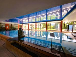 a large swimming pool in a building with a large building at Beatenberg Alpine Residence in Beatenberg