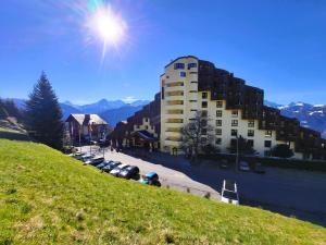 a building on the side of a hill with cars parked at Beatenberg Alpine Residence in Beatenberg