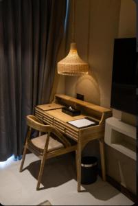 a desk with a lamp and a chair in a room at Pixcel Holidays in Calangute