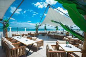 a restaurant with tables and chairs and a view of the ocean at White Tower Mamaia Beach 602 in Mamaia +27 photos