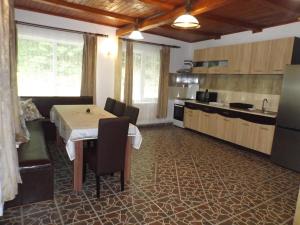 a kitchen with a table and chairs in a room at Cabana La Marian in Munună +31 photos
