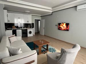a living room with a couch and chairs and a fireplace at Bediroğlu Airport Apart in Arnavutköy