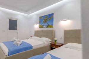 a bedroom with two beds with towels on them at Ksamil Guesthouse Villa in Ksamil