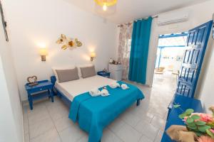 a bedroom with a bed with a blue blanket at Lunar Seaside Hotel in Perissa