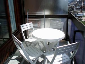 a white table and four chairs on a balcony at Le Bec Rouge in Tignes
