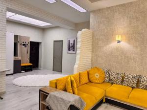 a living room with a yellow couch in a room at Zarisha Home in Fergana