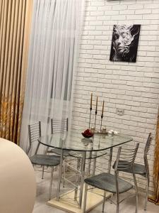 a dining room with a glass table and chairs at Zarisha Home in Fergana