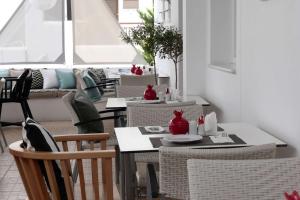 a dining room with tables and chairs and a couch at Apollon Boutique Hotel in Parikia