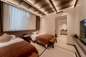 a hotel room with two beds and a television at 大理洱畔民宿 in Dali +155 photos