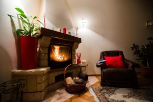 a living room with a fireplace and a chair at Interhouse Almaty in Almaty