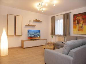 Apartments Obernosterer - Großglockner في كابرون: غرفة معيشة مع أريكة وطاولة