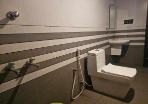 a bathroom with a toilet and a wall with stripes at Poomala Holiday Village in Mulagunnathukāvu