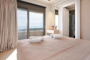 a bedroom with a large bed with two pillows on it at Lina's Luxury Villas in Skala +50 photos