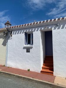 a white house with a window and a street light at La trinquette in Saint-Gilles-Croix-de-Vie