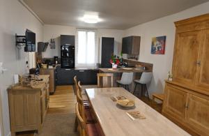 a kitchen and dining room with a wooden table at gîte MAELYSE in La Neuve-Lyre +7 photos