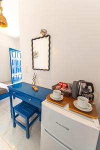 a blue desk with cups and saucers on a counter at Lunar Seaside Hotel in Perissa