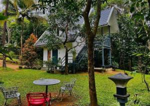 a table and chairs in front of a house at Poomala Holiday Village in Mulagunnathukāvu