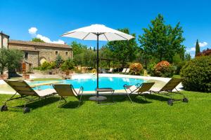 a group of chairs and an umbrella next to a pool at Sant'Ippolito in Asciano