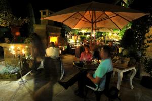 a group of people sitting at a table under an umbrella at Bonato Hotel in Náchod