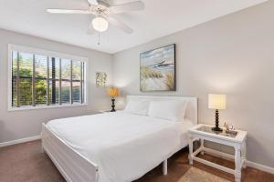 a bedroom with a white bed and a ceiling fan at Harbour Oaks, Unit 419 in Saint Simons Island +12 photos