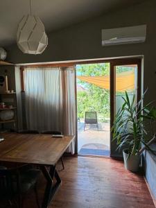 a dining room with a wooden table and a sliding glass door at Nyúlászó Vendégház Stúdiólakás in Mád +30 photos