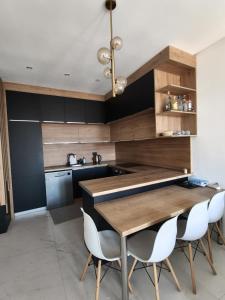 a kitchen with a wooden table and white chairs at Elia in Bečići