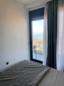 a bedroom with a window with a view of the ocean at Elia in Bečići +6 photos