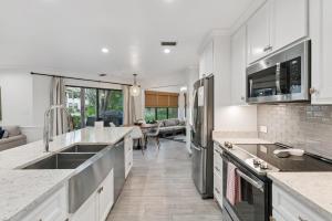a kitchen with white cabinets and appliances and a living room at Harbour Oaks, Unit 413 in Saint Simons Island