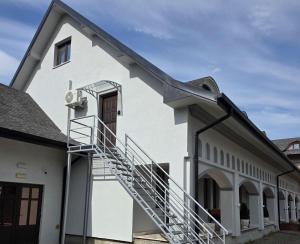 a white building with a spiral staircase on the side at Silent Retreat, Boutique Suite inside Monastery in Suceava