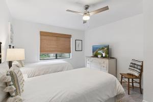 a white bedroom with two beds and a window at Harbour Oaks, Unit 413 in Saint Simons Island
