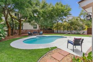 a swimming pool in a yard with chairs and trees at Sea Renity - 4333 Twelfth Street in Saint Simons Island