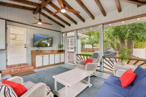 a porch with a blue couch and chairs and a tv at Sea Renity - 4333 Twelfth Street in Saint Simons Island