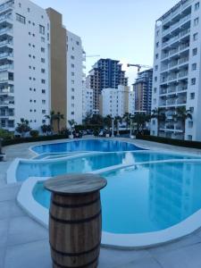 a large swimming pool in a city with tall buildings at Caesar Resort, Epictetus,Iskele, North Cyprus in Iskele
