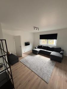 a living room with a black couch and a rug at High Coast Stay Floor 2 in Ramvik