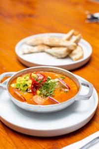 a bowl of soup on a table with a plate of food at Delgadillo Boutique Hotel by Socialtel in Bogotá