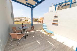 a patio with a table and chairs on a balcony at Lunar Seaside Hotel in Perissa