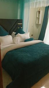 a bedroom with two beds with blue and white pillows at Sylvan hotel in Kasangati
