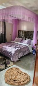 a purple bedroom with a bed with a canopy at Sylvan hotel in Kasangati
