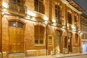 a brick building with a large wooden door at Delgadillo Boutique Hotel by Socialtel in Bogotá