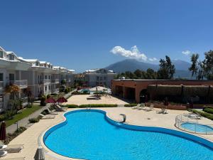 a pool at a resort with mountains in the background at Defne Beach Makri in Fethiye