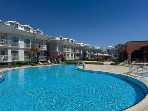 a large blue swimming pool in front of some apartments at Defne Beach Makri in Fethiye