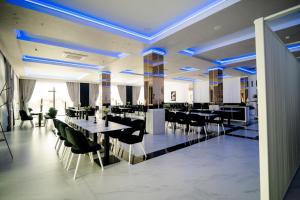 a dining room with tables and chairs and blue lights at Leo Resort and Spa in Petrova
