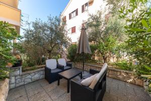 a patio with a table and chairs and an umbrella at Villa Zubčić in Zadar