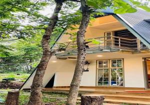 a house with two trees in front of it at Poomala Holiday Village in Mulagunnathukāvu