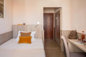 mała sypialnia z łóżkiem i biurkiem w obiekcie Hotel La Pace w Pizie