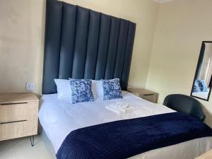 a bedroom with a large bed with a blue headboard at Nvivi boutique hotel in Polokwane