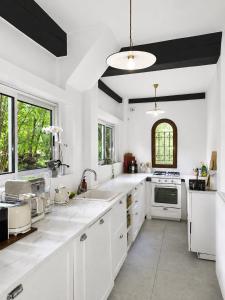 a white kitchen with white cabinets and a sink at Lake House by Veneto Villa in Albignasego +21 photos