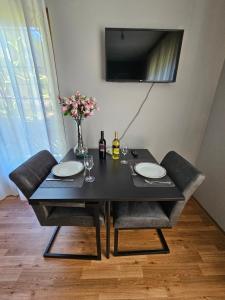 a black table with two chairs and a vase with flowers at Mirnockblick Apartments in Radenthein