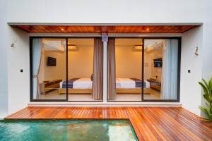 a room with glass doors and a swimming pool at Tapan Harmony Villa Ubud in Ubud +22 photos